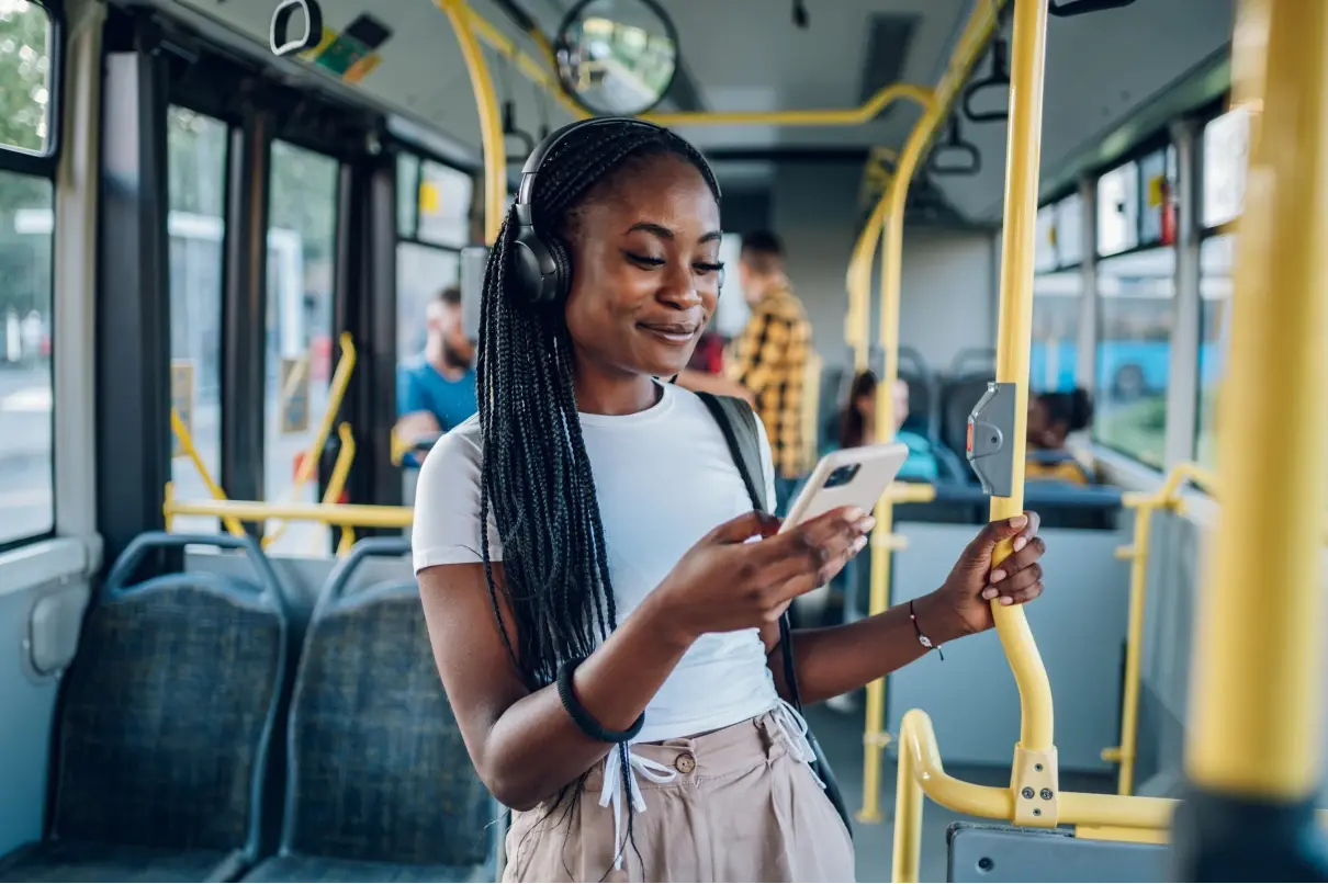 African American woman using smartphone while riding a bus